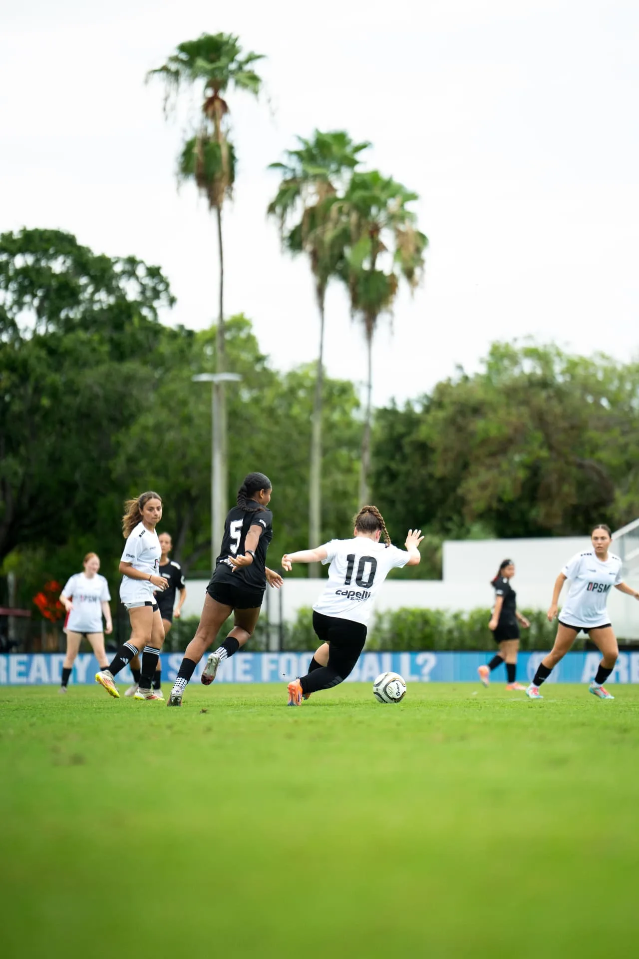 Number ten in white pushing the ball past a defender