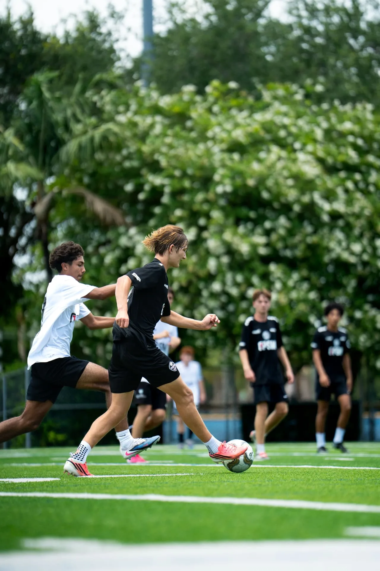 Player driving the ball forward under pressure from a defender
