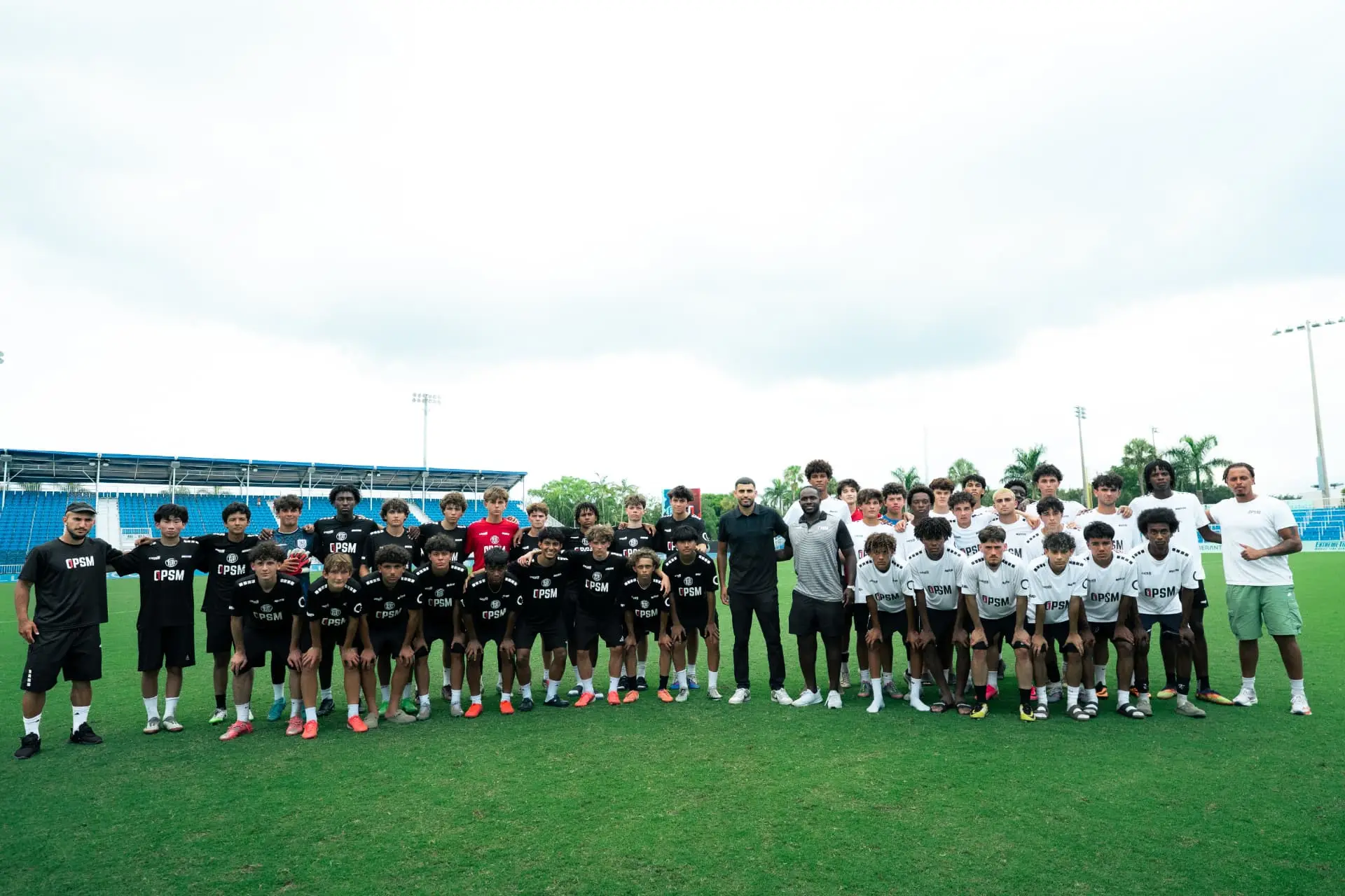 Boys squad group photo with coaches at the stadium