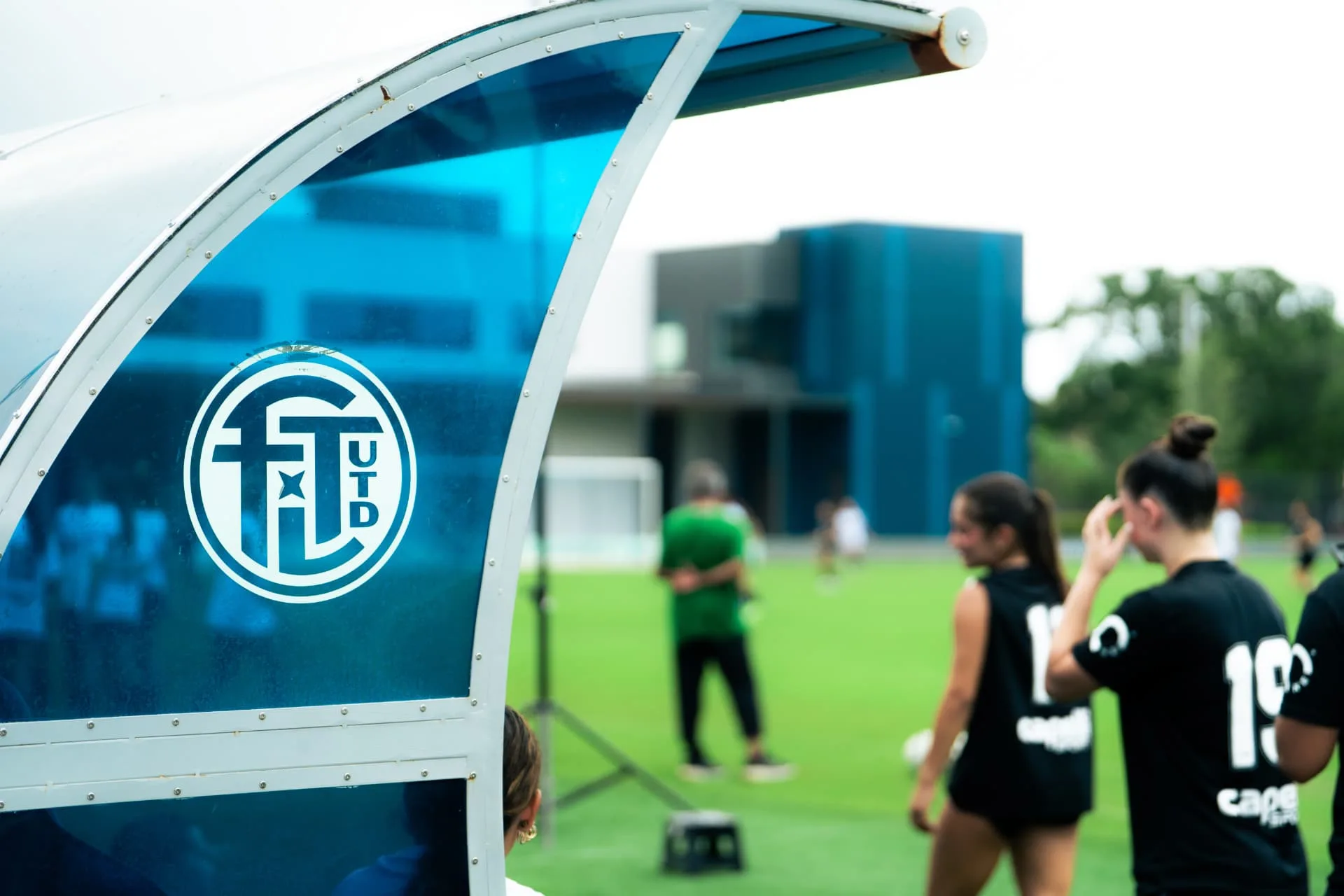 Fort Lauderdale United crest on the team shelter beside players