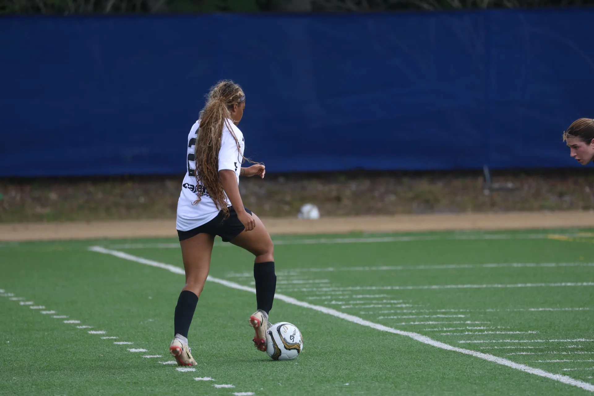 Player in white kit setting up a pass on the touchline