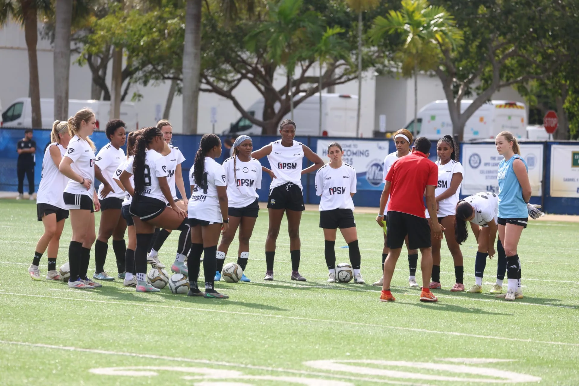 White squad listening to coaching instructions on the field