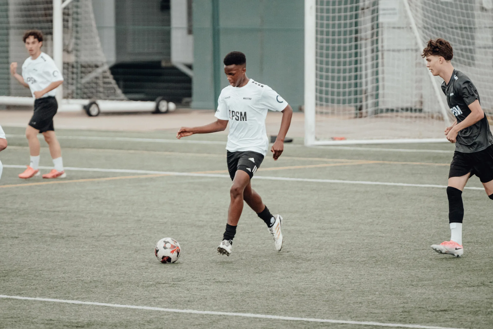 Player in white kit driving at goal with the ball