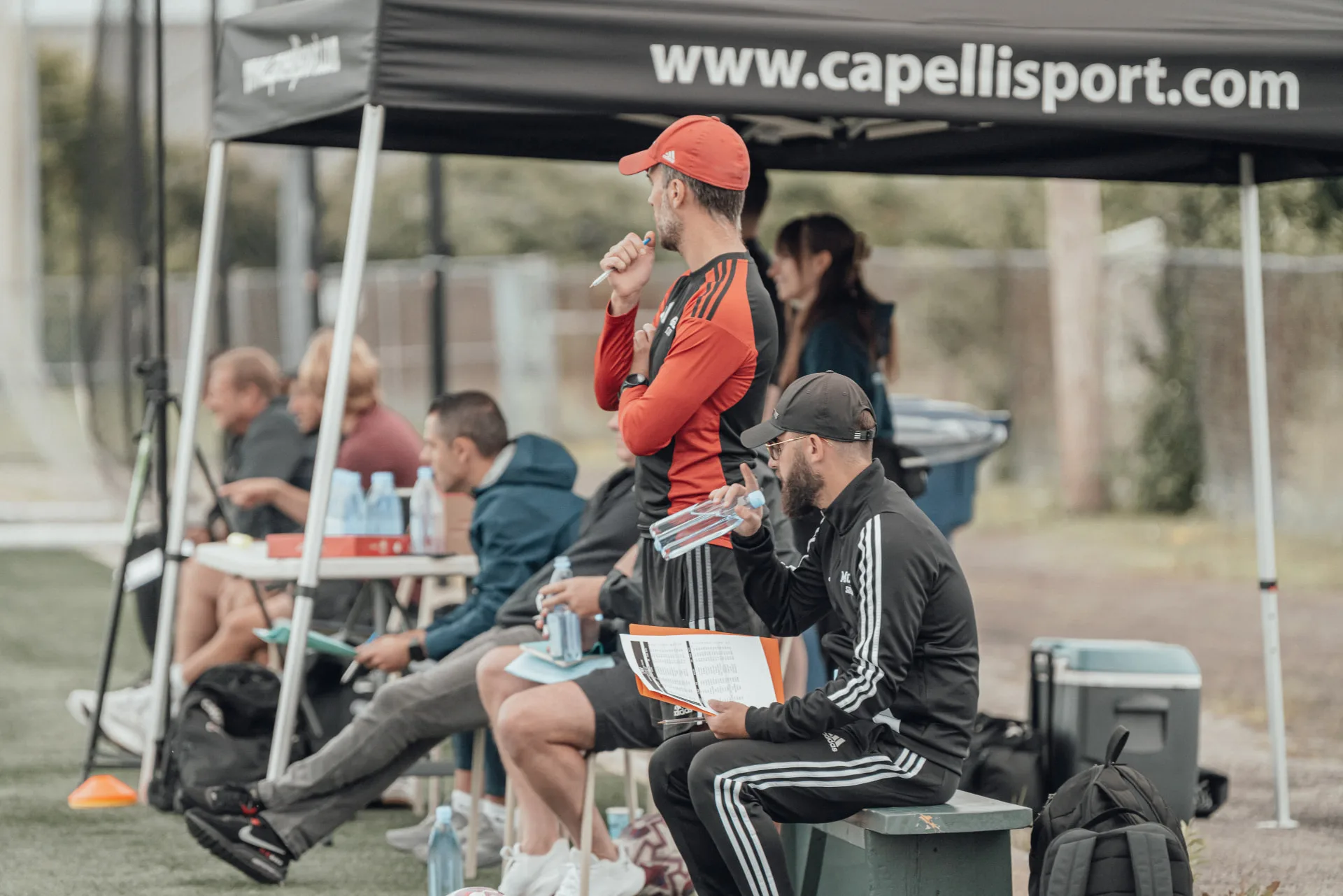 Scouts and coaching staff evaluating from the tent