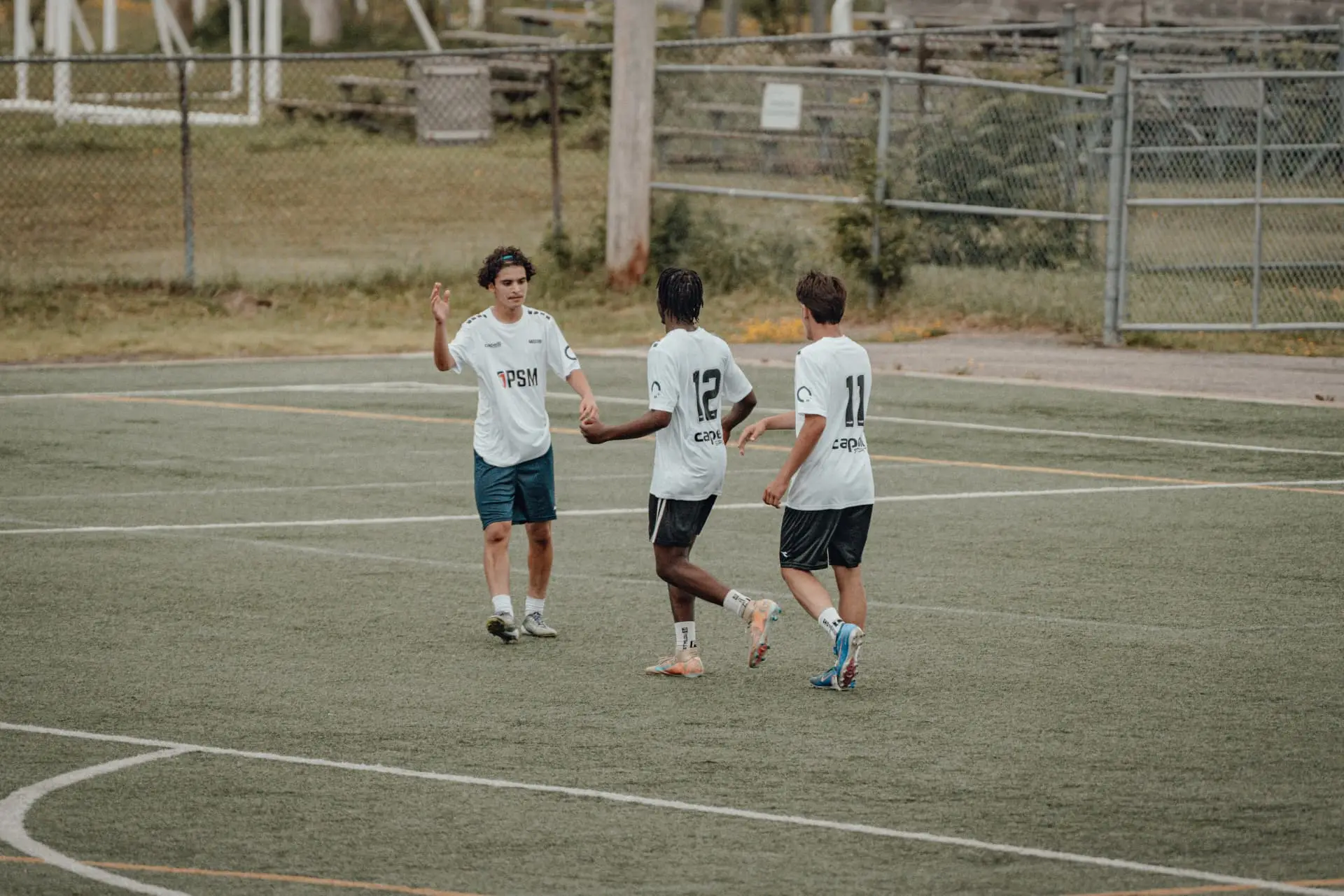 Three players celebrating after a goal