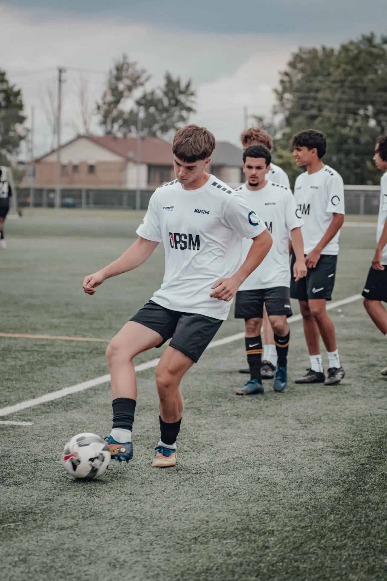 Player in white kit striking the ball during drills