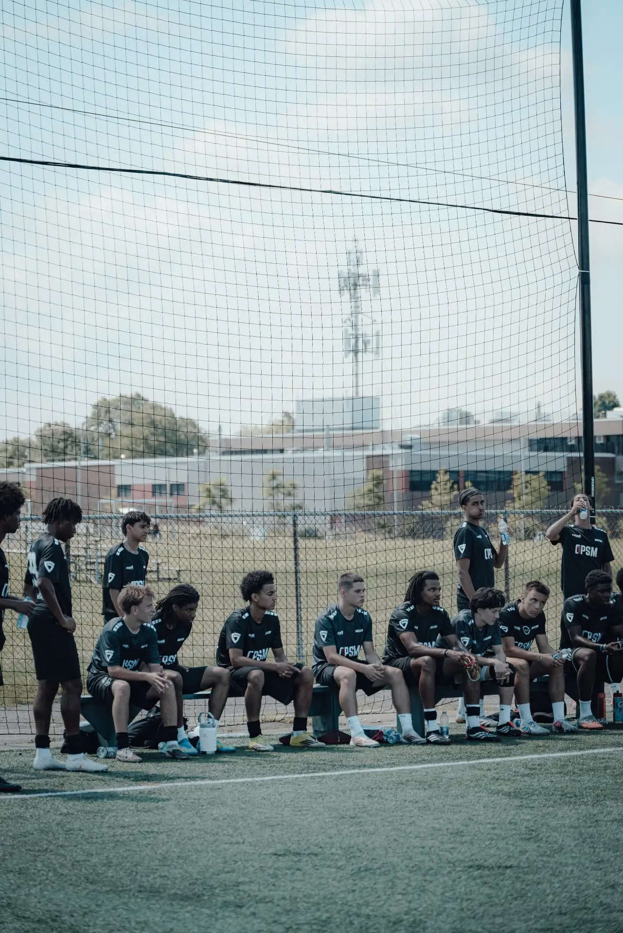 Players in OPSM kits waiting on the bench between matches