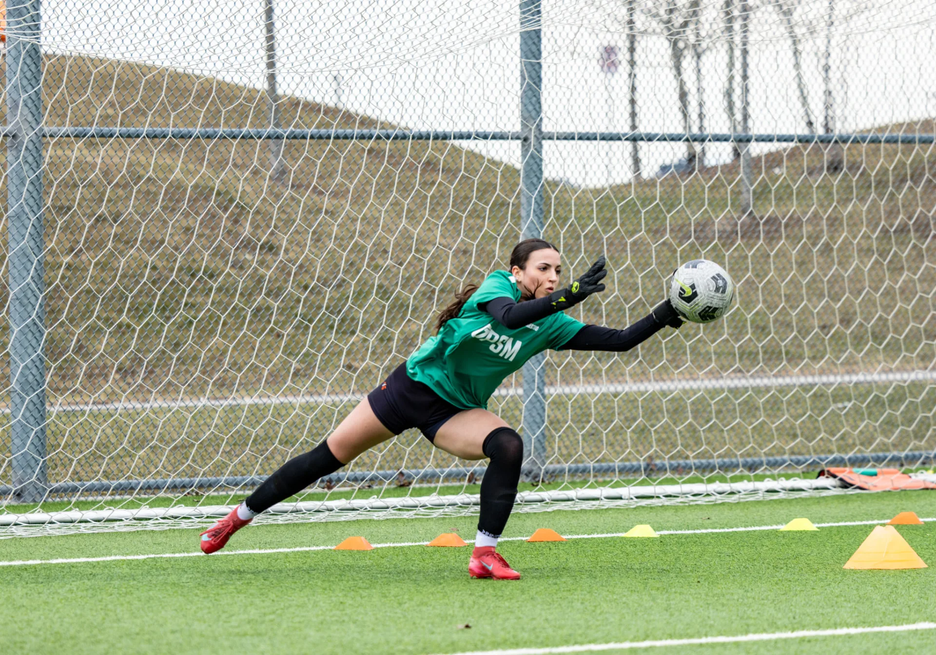 Goalkeeper making a diving save during warm-ups
