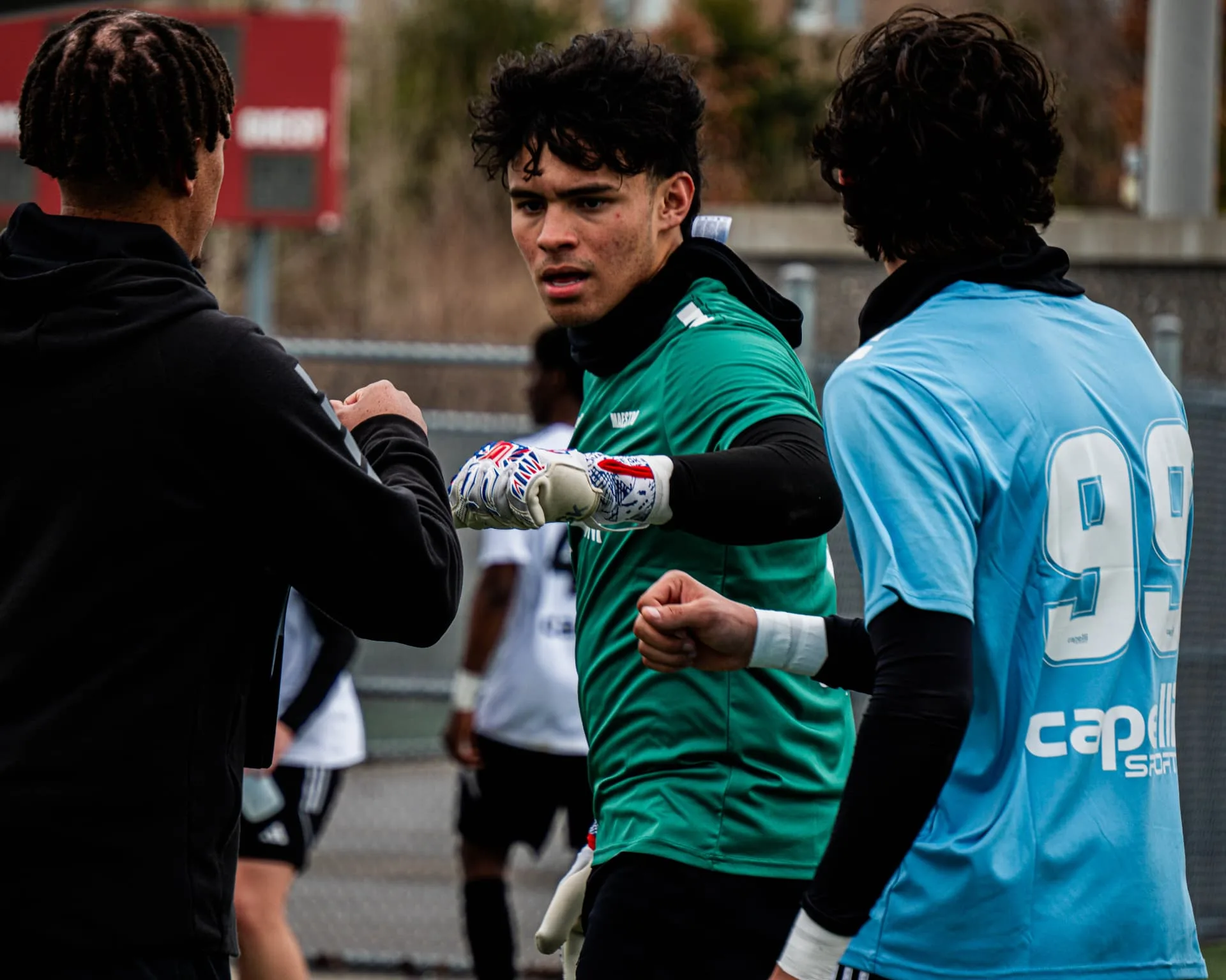 Goalkeeper talking with coaching staff on the sideline