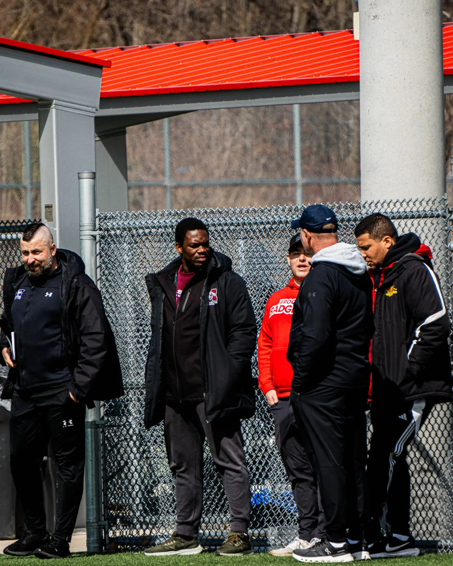 University coaches and scouts observing the combine