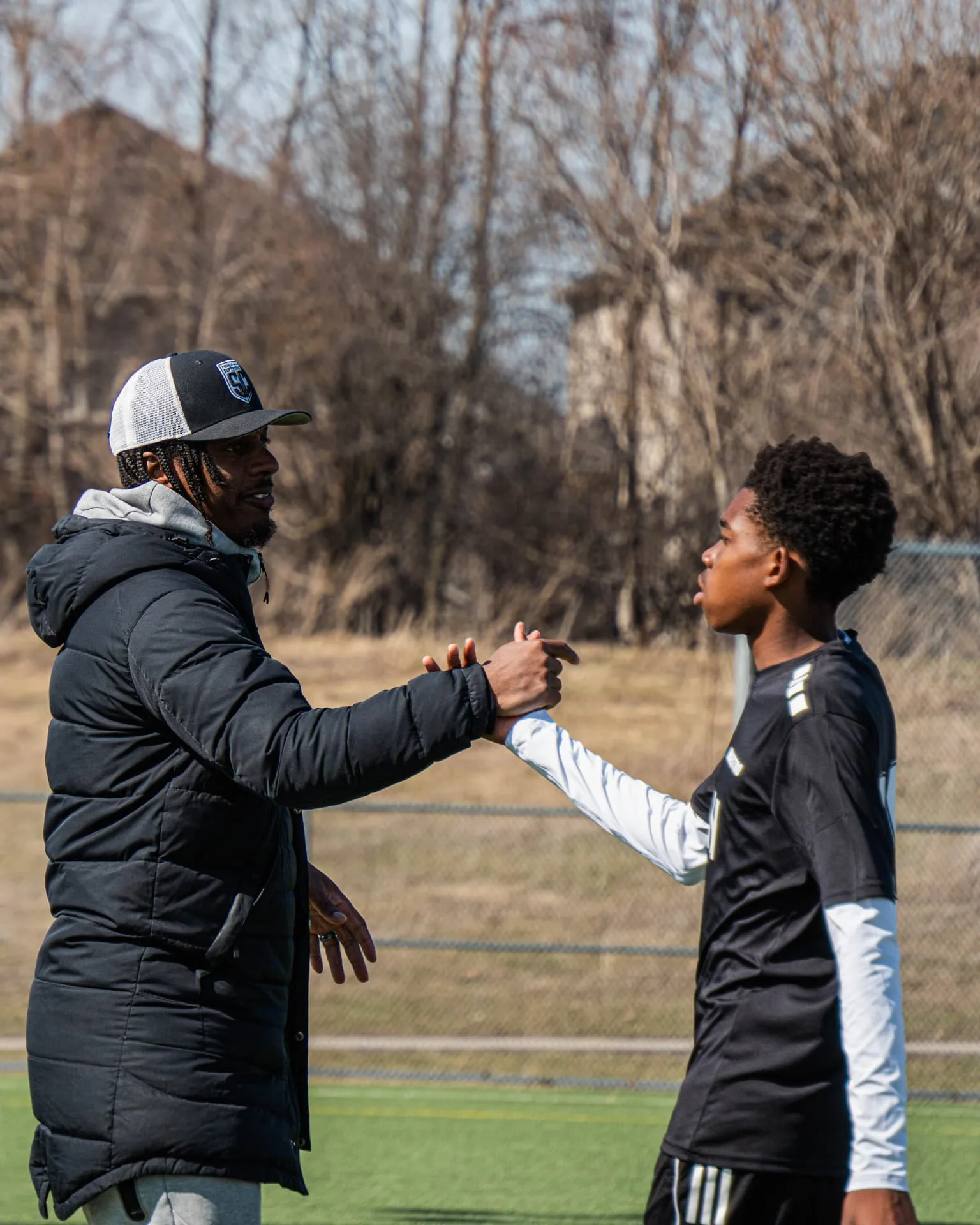 Coach greeting a player as he comes off the field