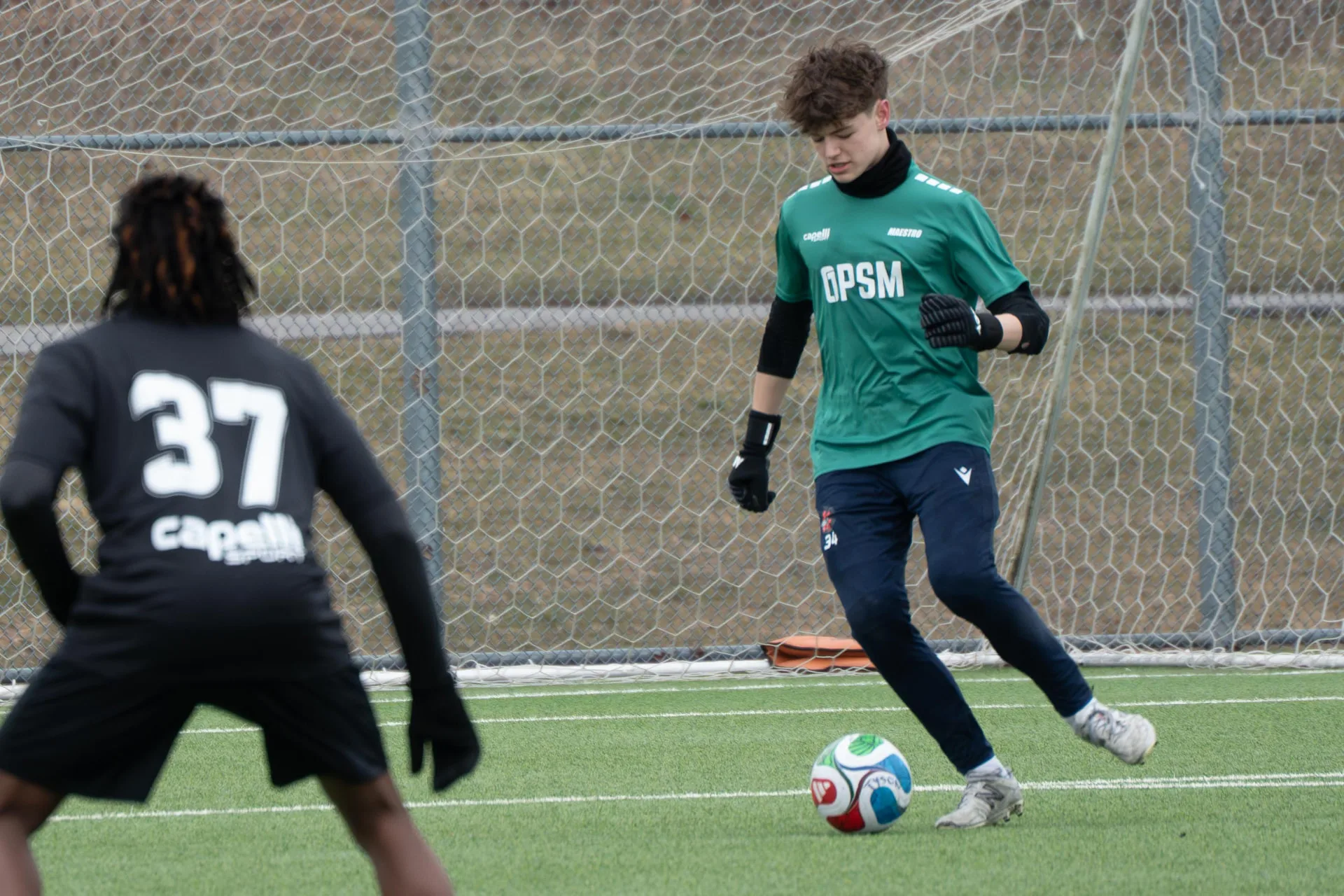 Goalkeeper in green kit playing out from the back