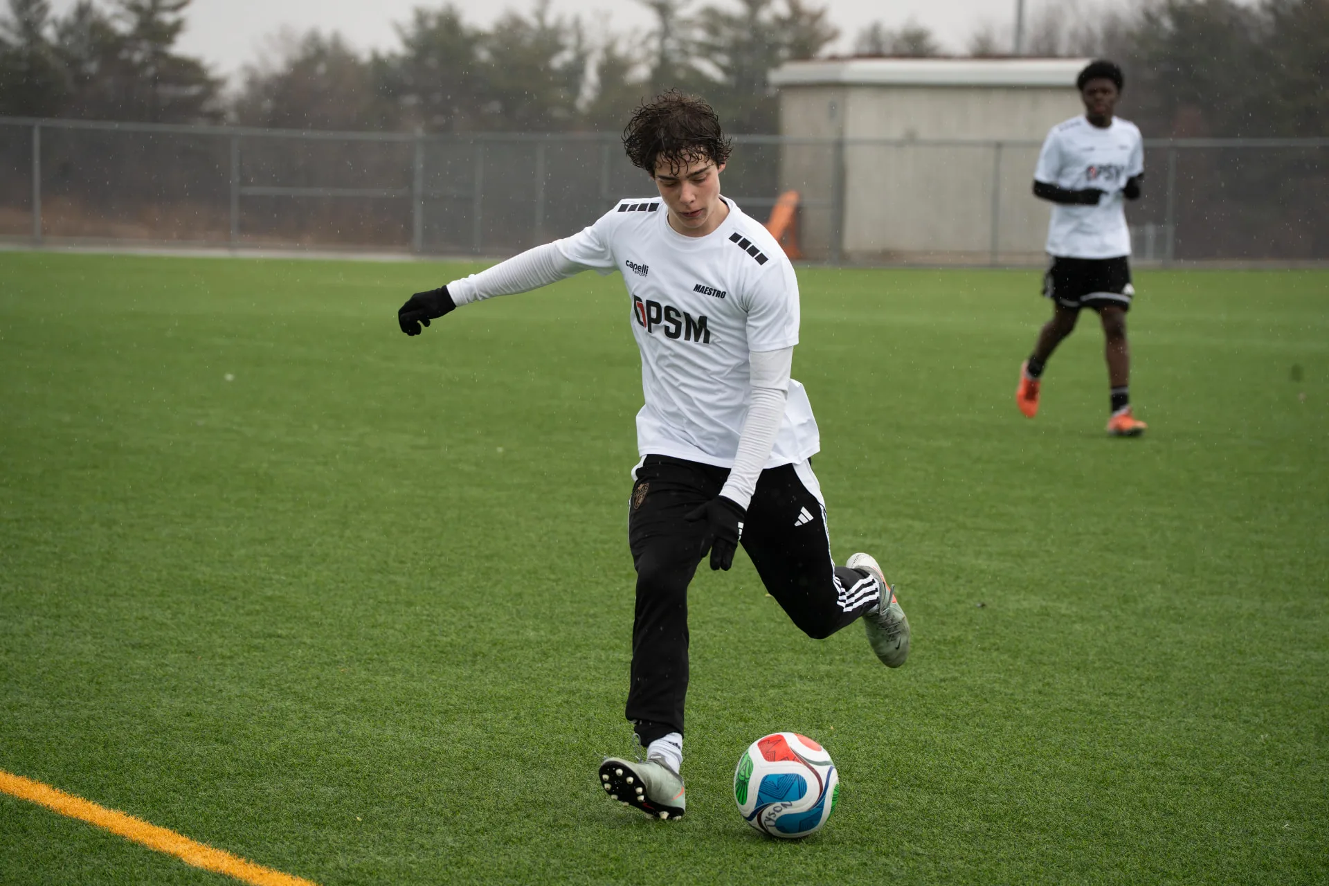 Player striking the ball in the rain during the combine match