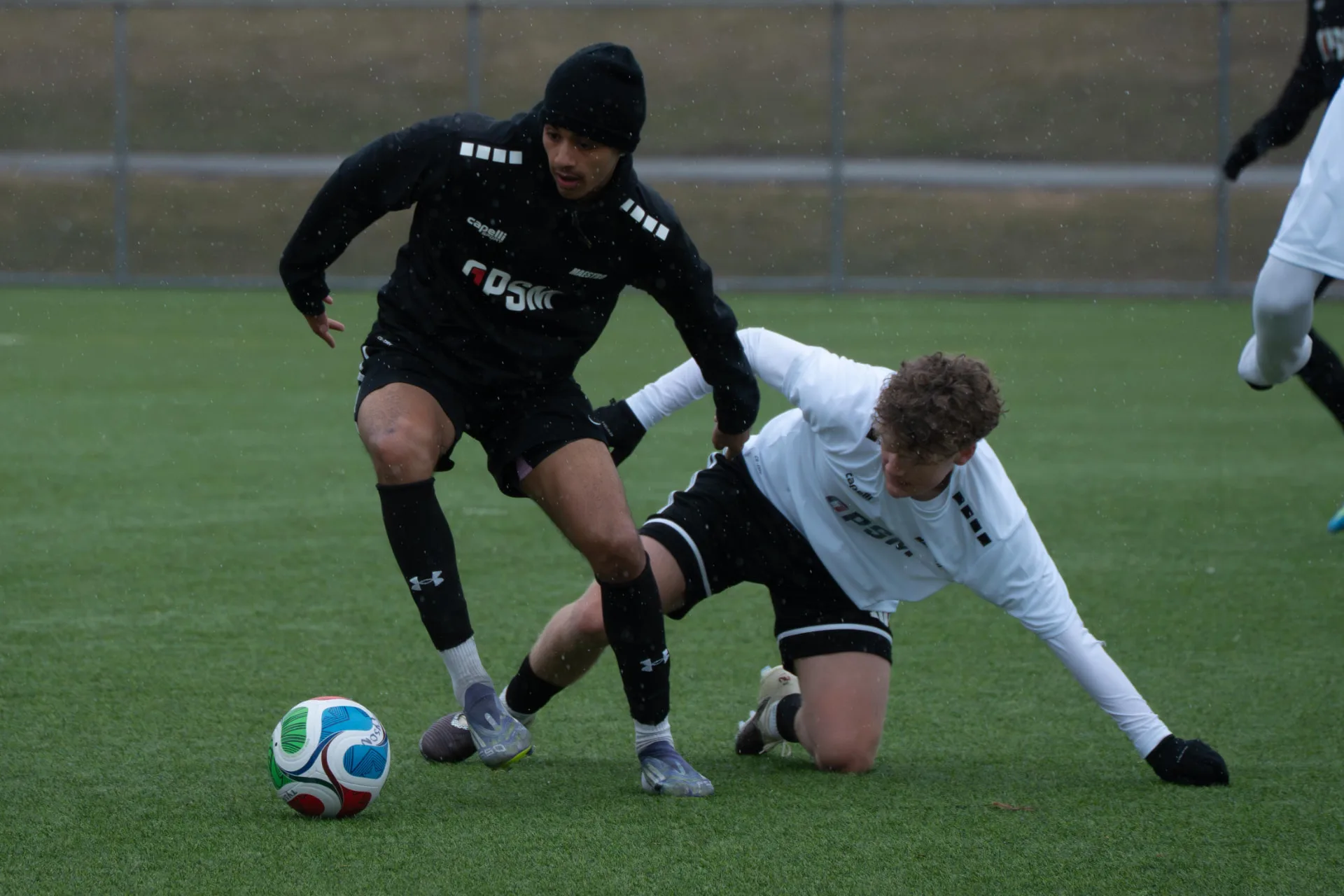 Player shielding the ball as an opponent slides in